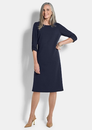 Elegant woman over 50 wearing a navy crepe sheath dress