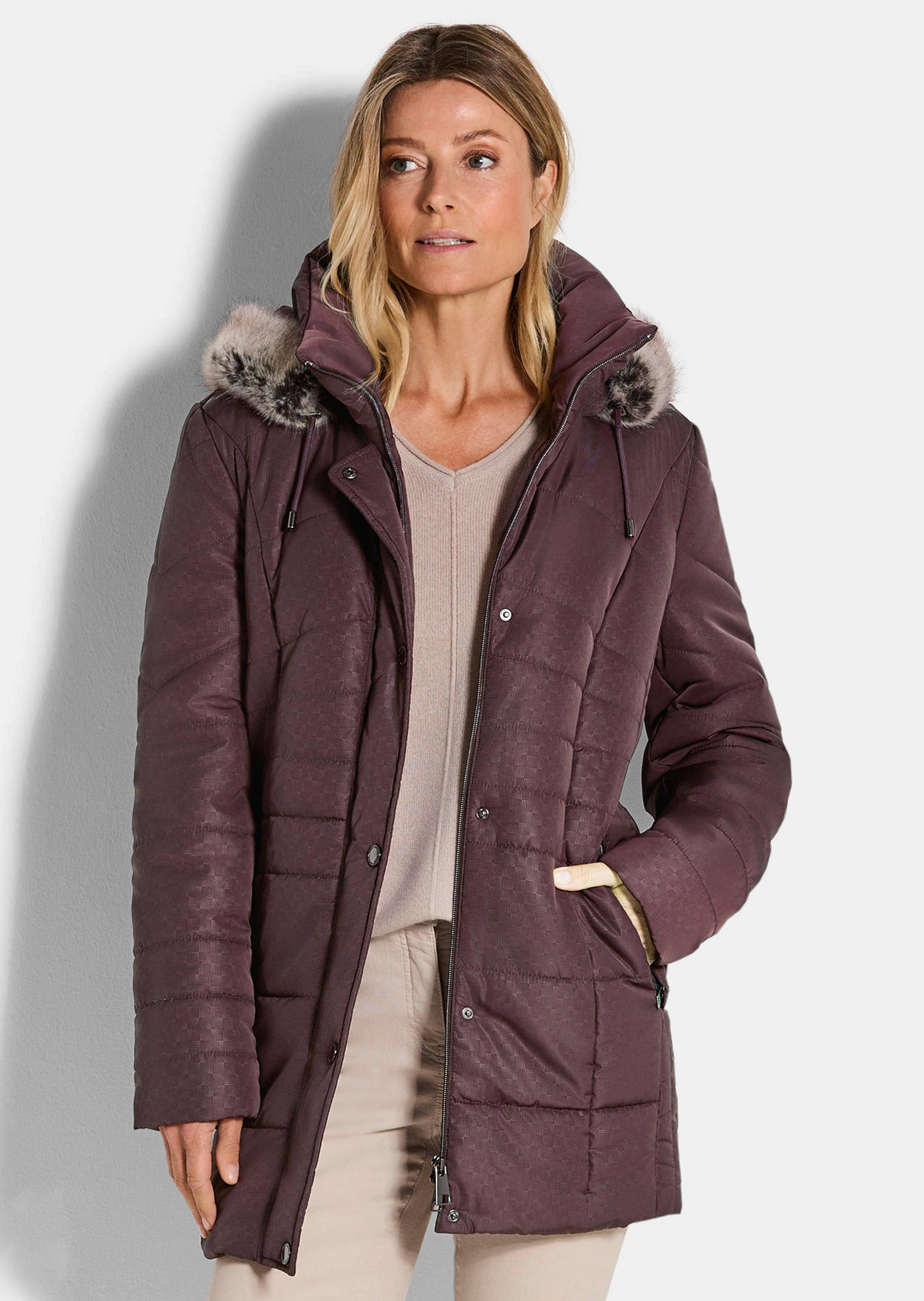 Manteau matelassé court avec capuche et tissu aspect fourrure